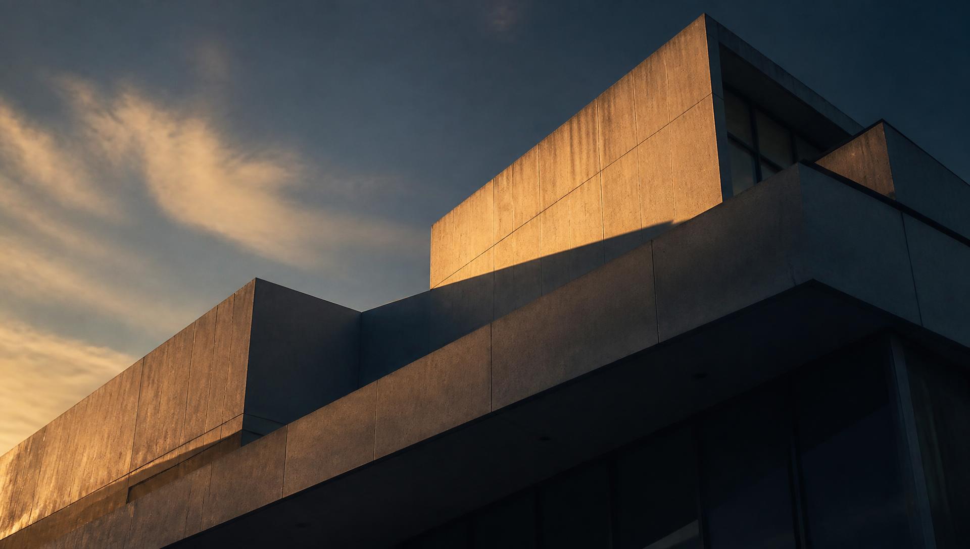 Estrutura arquitetônica contemporânea em concreto e vidro sob luz de fim de tarde, representando solidez patrimonial